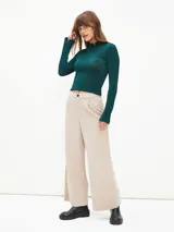 Pantalón de vestir color beige, de corte recto y tiro alto, con cierre frontal de botón y pinzas en la cintura.