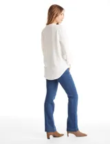 Blusa de color blanco con escote en V y cuello mao. Presenta mangas largas con presilla y botón para regular el largo, y un corte holgado con ruedo redondeado.