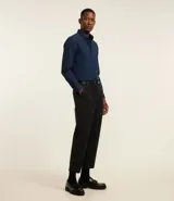 Camisa blanca de corte regular, confeccionada en tejido Oxford de algodón, con cuello inglés, mangas largas y cierre frontal abotonado.