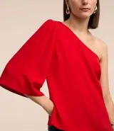 Blusa roja de crepé con un solo hombro descubierto y manga 3/4 abullonada.