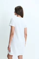 Camisón corto de algodón color blanco, con cuello redondo, cierre frontal parcial con botones y detalle de calado en mangas y ruedo.