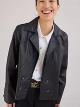 Chaqueta de jean azul oscuro, de corte corto y entallado, con cuello y solapa, y botones de madera en el frente.