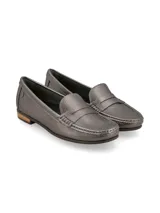 Mocasín de cuero color plomo, con diseño clásico de líneas simples, costuras pespunteadas en el empeine y detalle de remache metálico con logo en el lateral.