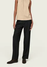 Pantalón sastrero negro de corte recto y tiro alto, con pinzas delanteras y bolsillos laterales.