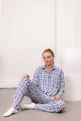 Conjunto de pijama de dos piezas, color verde menta con estampado de cuadros irregulares en blanco. Incluye camisa de manga larga con botones y pantalón largo con cintura elástica.