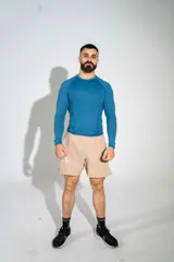 Short deportivo beige con aberturas en los costados y estampa lateral.