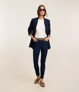 Pantalón de jeans azul oscuro, de corte recto, con cintura media, bolsillos delanteros y traseros, trabillas para cinturón y cierre con cremallera y botón.