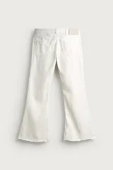 Jeans flare fit de tiro medio, confeccionados en denim de algodón color azul con efecto deslavado. Diseño ajustado en la parte superior y abierto en campana desde la rodilla, con cinco bolsillos y cierre frontal con cremallera y botón.