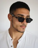 Lentes de sol negros con marco geométrico y patillas con diseño calado.