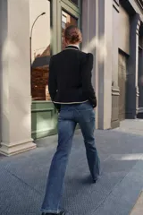 Jeans de tiro bajo y cintura ancha, con diseño bootcut de corte evasé desde la rodilla. Cuenta con cinco bolsillos y cierre frontal con cremallera y dos botones metálicos. Color azul con efecto desgastado.