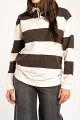 Sweater tipo polo de algodón con diseño de rayas horizontales anchas en color marrón y crema. Presenta cuello camisero, cierre frontal con botones ocultos y mangas largas con puños ajustados.