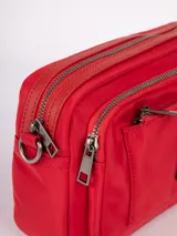 Bandolera roja de nylon con tres compartimentos, correa desmontable y regulable.