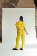 Pantalón amarillo de lino con bordados florales a lo largo de las piernas. El pantalón es de corte recto y tiro alto.