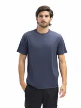 Remera de corte clásico y cuello redondo, confeccionada en tejido técnico respirable con acabado vintage. Presenta un diseño minimalista con una pequeña etiqueta distintiva en el ruedo inferior.