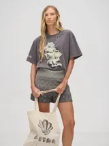 Remerón oversize de algodón, corte cuadrado y básico, color gris oscuro con efecto gastado. Estampa frontal de una figura abstracta o mano en tonos claros y texto en un idioma asiático en la manga.