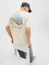 Remera color crema de algodón con cuello redondo y mangas cortas. Estampa en el frente con un paisaje costero, un auto rojo y la inscripción "Casares Málaga The creative studio".