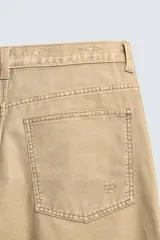 Pantalón straight fit de algodón con efecto lavado y roturas localizadas. Presenta diseño de cinco bolsillos, cierre frontal con cremallera y botón metálico.