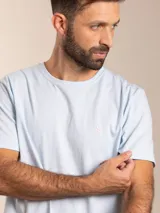 Remera básica de manga corta y cuello redondo, color blanco, con pequeño logo bordado en el pecho.