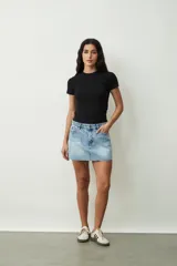 Minifalda de jean celeste con efecto lavado, tiro alto y ruedo desflecado.
