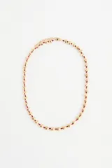 Collar largo con cuentas en forma de corazón color dorado, ensartadas en un cordón rojo.