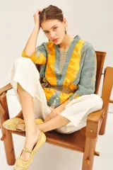 Kimono corto de viscosa con diseño estampado en tonos amarillo y gris, decorado con bordados en hilo de lurex. Presenta un corte holgado con mangas tres cuartos y un cinturón integrado de la misma tela.