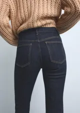 Pantalón de jean estilo flare con tiro alto, confeccionado en tejido de algodón con elasticidad. Presenta diseño de cinco bolsillos, cierre de botón y cremallera, y trabillas para cinturón.
