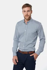 Camisa de manga larga con cuello abotonado y estampa a cuadros en tonos de azul y blanco. Presenta un bolsillo aplicado en el pecho con detalle de bordado y cierre frontal con botones.