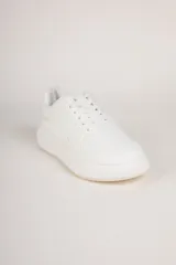 Zapatillas blancas de símil cuero con recortes en distintas texturas y plataforma de 4cm de alto.
