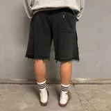 Short de algodón con efecto desgastado, corte baggy holgado, cintura elástica con cordón ajustable y bordes deshilachados.