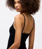 Musculosa de rib color negro, con breteles finos y escote en V con detalle de encaje blanco en el borde superior y en el ruedo.