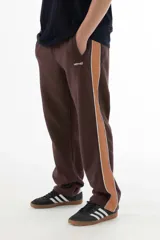 Pantalón de jogging marrón con banda lateral color caramelo y línea blanca.