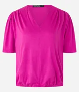 Blusa fucsia de viscolycra crepada, con escote en V y mangas cortas con detalle de pliegues en los hombros.