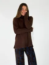 Sweater de punto color marrón chocolate, con cuello alto, mangas largas y diseño holgado con aberturas laterales en el ruedo.