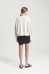 Minifalda negra de viscosa, ajustada al cuerpo, con corte irregular en el frente y cintura elástica.
