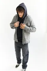 Sobrecamisa escocesa de paño en tonos blanco, negro y marrón. Corte recto con cuello camisero, cierre frontal con botones, dos bolsillos de parche en el pecho y puños abotonados. Disponible en tallas S a XL.