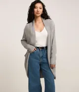 Cardigan alargado de punto color gris, sin cierre frontal y con mangas largas.