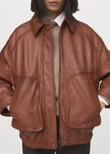 Chaqueta de cuero de ovino en color marrón, de diseño oversize con cuello clásico, cierre frontal con botones a presión y bolsillos frontales con solapa.