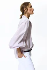 Camisa de algodón color lila, con cuello camisero ribeteado en encaje, cierre frontal de botones con detalles de encaje a los lados y mangas globo largas con puños elásticos.