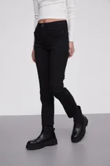 Pantalon jean de corte skinny y tiro alto, con diseño clásico de cinco bolsillos y cierre frontal con botón y cremallera.