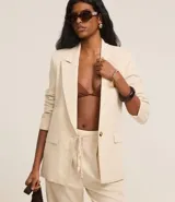 Blazer celeste de viscosa y lino, con cuello inglés, cierre de un botón y solapas.