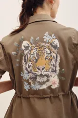 Campera estilo militar color verde militar, con cierre frontal, bolsillos con solapa en el pecho y cordón ajustable en la cintura. Presenta el texto "WILD LOVE" estampado en el pecho.