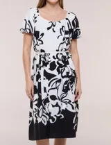 Vestido midi de calce fluido con escote redondo y mangas cortas abullonadas con terminación elástica. Presenta un fino cinturón a tono para ajustar la cintura y una falda evasé con estampa floral abstracta en blanco y negro.