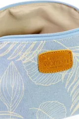 Estuche necessaire de lona tipo canvas color crudo con estampado de flores en color lila. Tiene cierre superior con tirador de cuero marrón y manija lateral de cuero marrón.