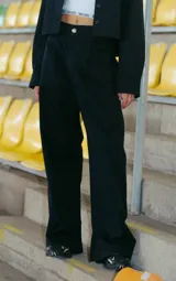 Pantalón negro de gabardina elastizada, corte sastrero, tiro bajo y pierna ancha. Tiene bolsillos delanteros, botón metálico con logo RENÉE y tajo en el lateral interno.