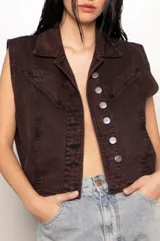 Chaleco vintage de jean color marrón oscuro, con cuello solapa, cierre frontal con botones metálicos, bolsillos delanteros con solapa y corte oversize.