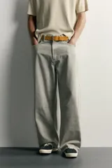 Pantalón barrel fit de mezclilla color verde militar, con efecto lavado, cinco bolsillos, cierre frontal con cremallera y botón, y detalle de pinzas en las rodillas.