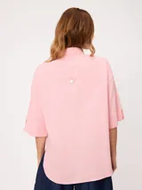 Camisa de manga corta celeste, confeccionada en mezcla de algodón y lino, con cuello camisero y cierre frontal de botones.