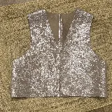 Chaleco de cuero con acabado metalizado plateado, diseño sin mangas, escote en V y corte recto.