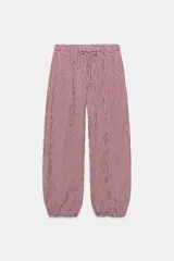 Pantalón bombacho con estampado de cuadros vichy en color rojo y blanco, cintura elástica con cordón de ajuste y puños elásticos en los tobillos.