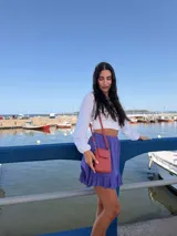 Bandolera pequeña tipo porta celular, color verde claro, confeccionada en cuero sintético. Cuenta con cierre principal, bolsillo frontal con tapa y broche a presión, y correa ajustable extraíble.